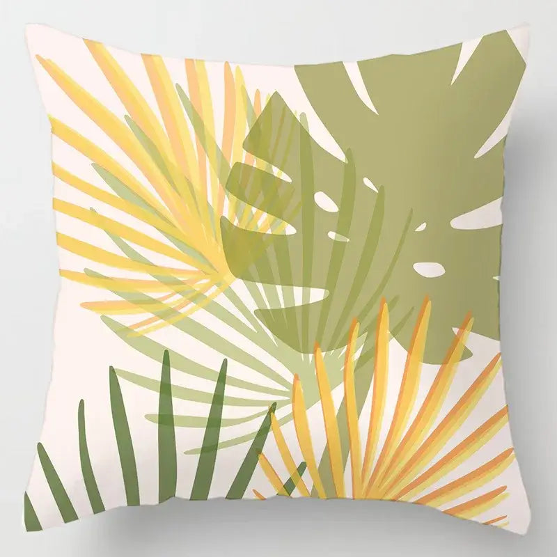 A square throw cushion cover with a vibrant geometric leaves print in yellow green and olive on off-white fabric