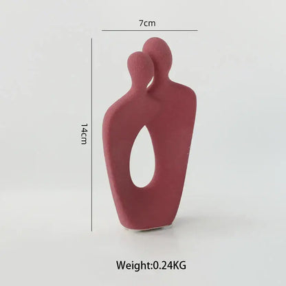 Minimalist red ceramic art couple statue with two abstract figures embracing and an oval cutout for living room decor
