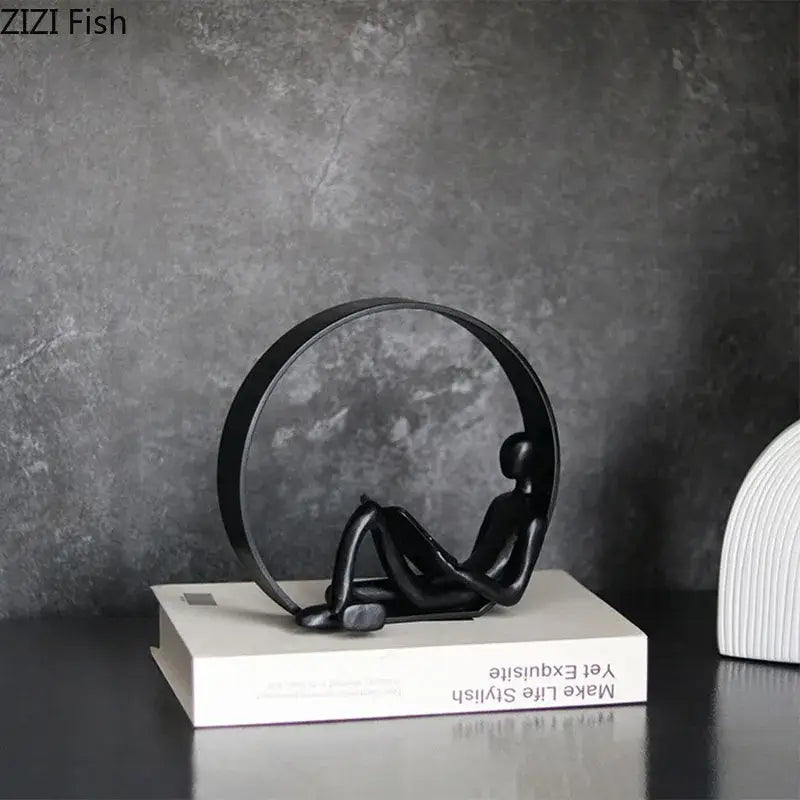 Black minimalist abstract resin characters seated figurine with ring on white book for home decor by decorbites
