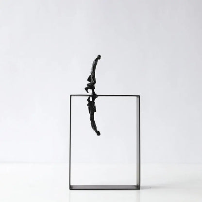 Black metallic resin sculpture of a man balancing on the edge of a transparent glass cube for living room decorbites abstract resin decor