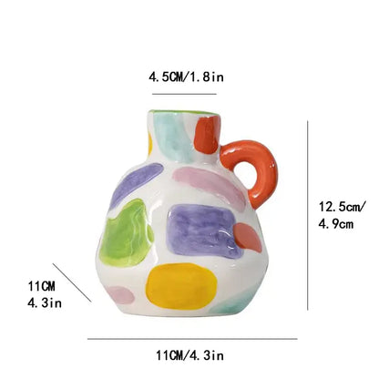 A white ceramic vase teapot with orange handle and colorful abstract patches for decorbites cartoon ceramic decor