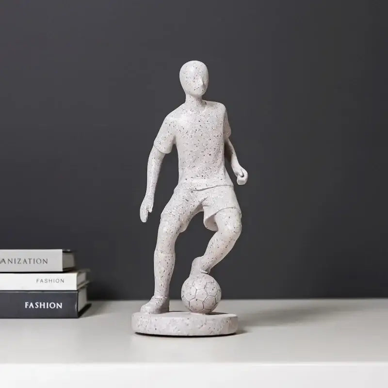 White speckled resin abstract sports player sculpture in grey and white standing on a base with a detailed ball decorbites abstract sports