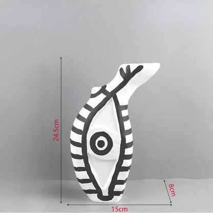 Abstract white ceramic vase with bold black stripes and geometric eye pattern featuring an abstract fish shape for decor
