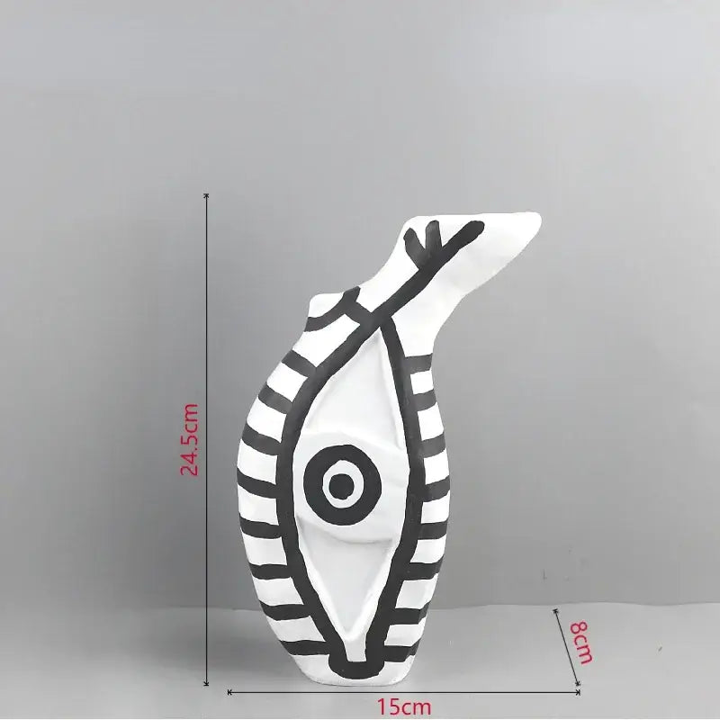 Abstract white ceramic vase with bold black stripes and geometric eye pattern featuring an abstract fish shape for decor