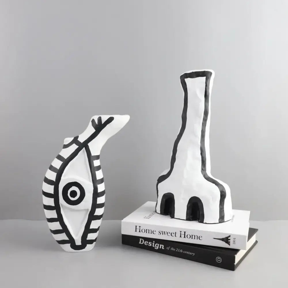White ceramic vases with bold black geometric eye pattern featuring stylized fish and elongated figure for living room decor