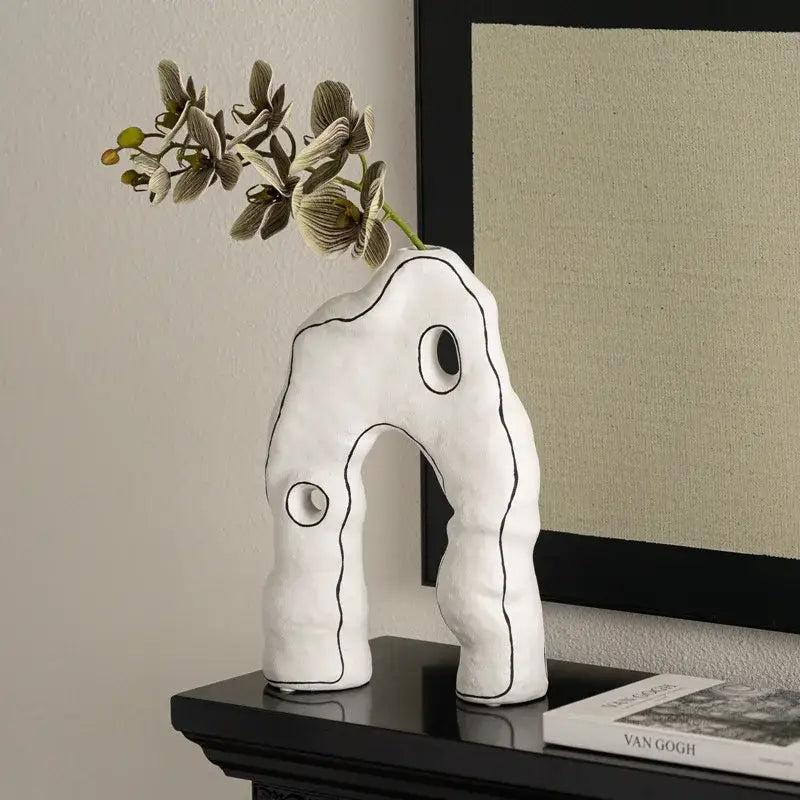 Abstract white and black geometric ceramic vase with black outlined organic shapes and circular cutouts for living room decorbites decor