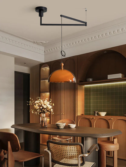 Warm amber glass acrylic pendant light with dark wood lampshade and black metal arm fixture for elegant lighting