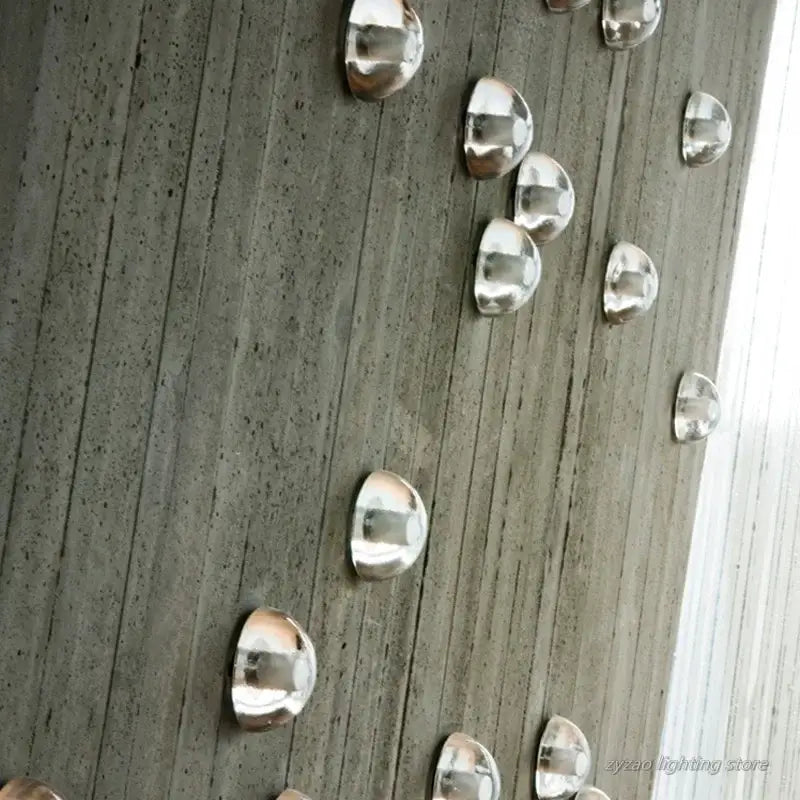 Shiny silver dome-shaped metal caps mounted on gray wood surface for amber and gold textured crystal led wall lamps decorbites crystal led