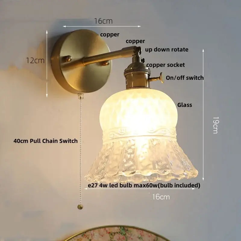 Antique brass-finished wall light fixture with amber flower crystal glass and textured frosted shade for bedroom use