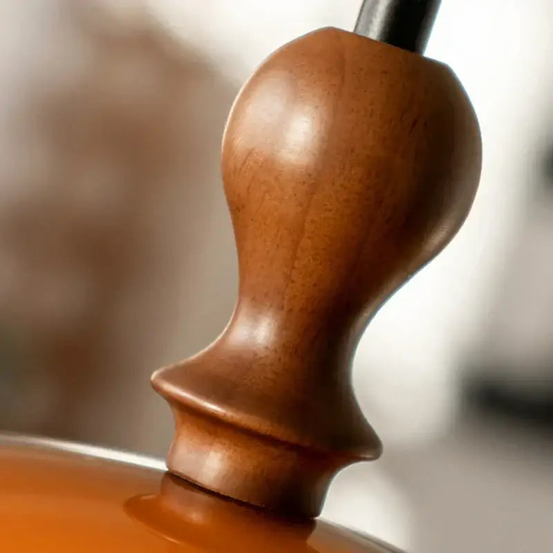 Polished walnut wood tuning peg with dark brown finish as part of amber glass and dark wood accent pendant light
