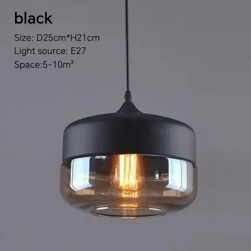 Black pendant light fixture with matte metal top and translucent amber glass shade for dining room use