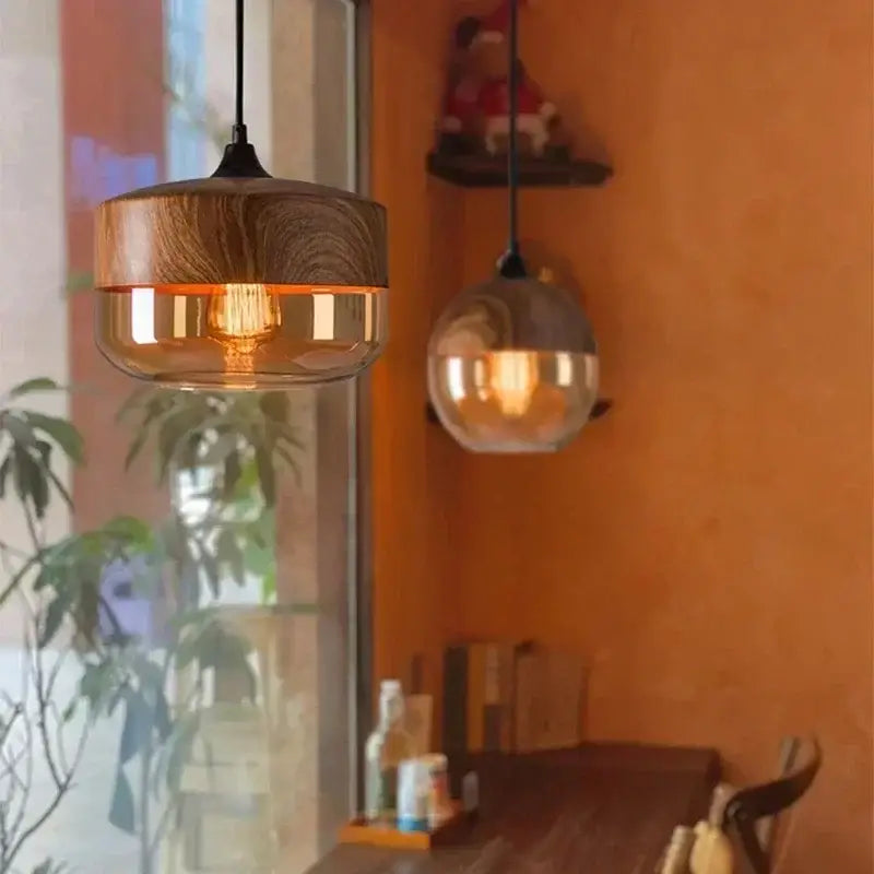 Warm-toned pendant light fixture with amber glass shade and natural wood top for dining room lighting