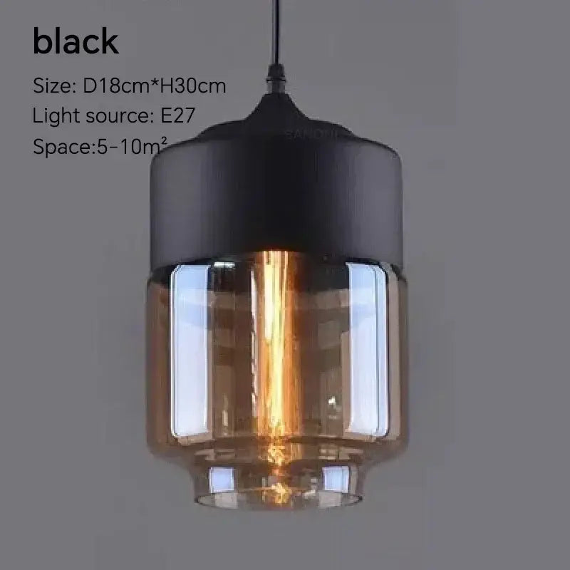 Black pendant light fixture with cylindrical glass shade and exposed edison bulb for dining room lighting