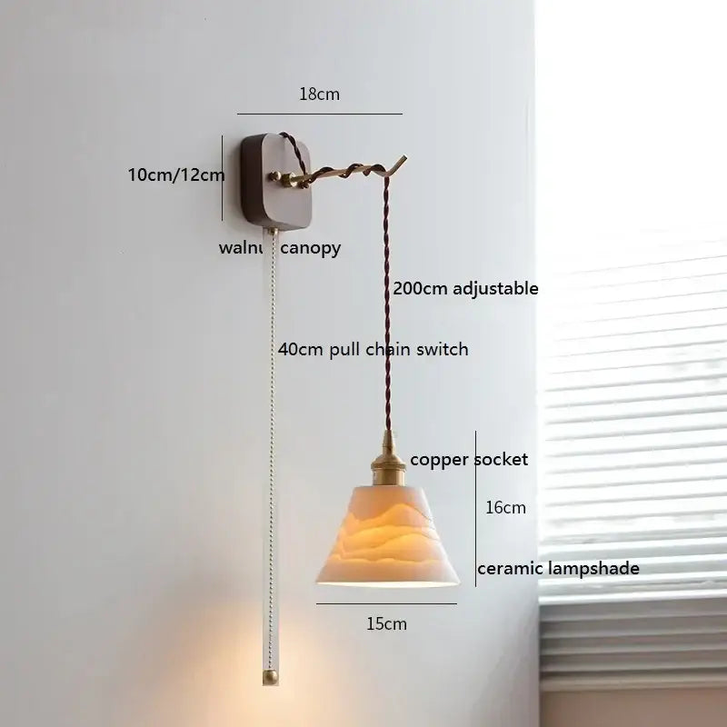 A warm-toned amber ceramic ball led wall light with textured surface and pull chain on walnut canopy by decorbites ceramic ball