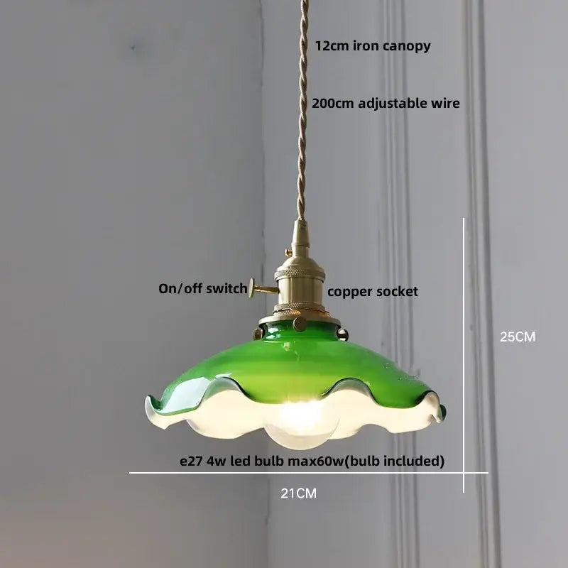 Green glass pendant light with scalloped edge and brass-finished metal components featuring decorbites brass knob switch