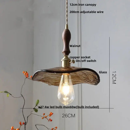 Amber glass pendant light with dark walnut wooden canopy and decorbites brass knob switch for elegant dining room lighting