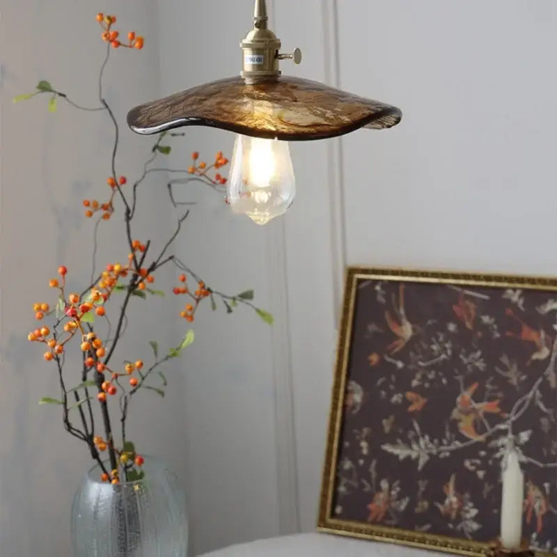 A warm amber glass pendant light with a brass knob switch and exposed bulb for dining room decorbites brass knob