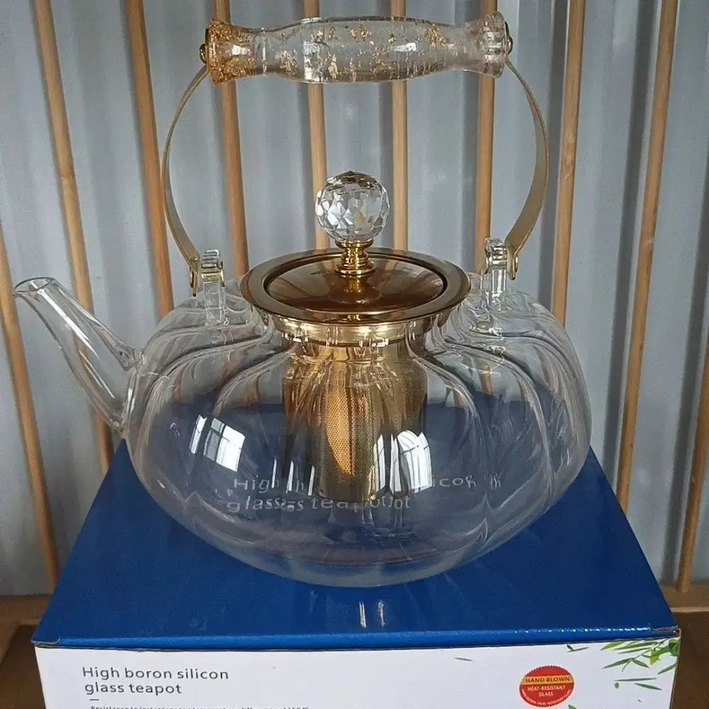 Amber glass teapot with gold infuser features clear glass, gold-toned metal accents, and a crystal knob lid for kitchen use