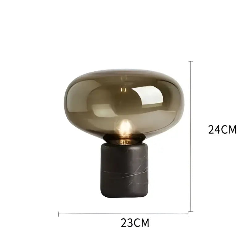 Amber nordic table lamp with a translucent amber glass dome and dark marble textured base for modern decor