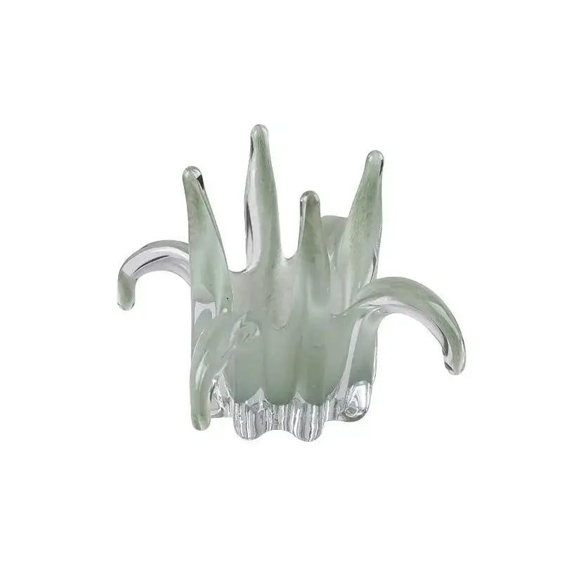 Translucent green glass petal candle holder with curved arms and textured base for living room decor