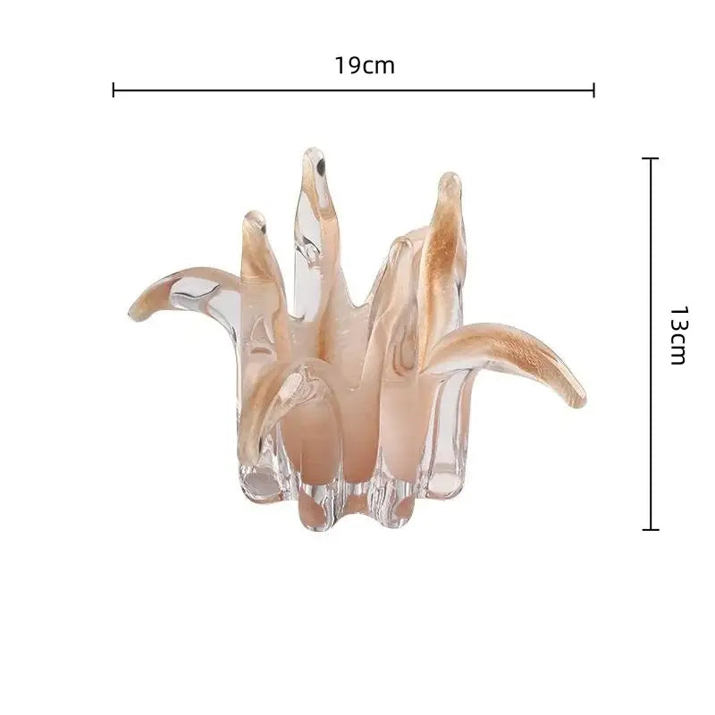 A translucent peach-colored glass petal candle holder with an organic flower design for living room decor