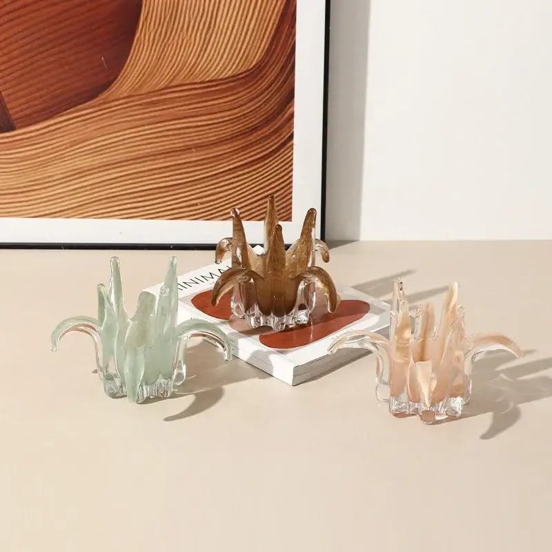 Amber and pale green glass petal candle holder featuring three translucent stylized cactus sculptures in mint, amber, and peach hues