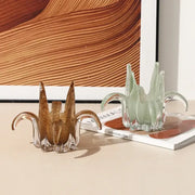 Two translucent glass petal candle holders in amber and pale green with sculpted leaf-like arms for living room decor