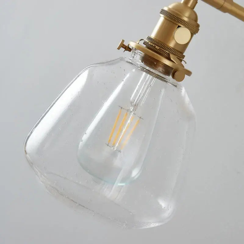 Amber textured clear glass wall sconce with brass fixture and exposed filament bulb by decorbites clear glass for bedroom use