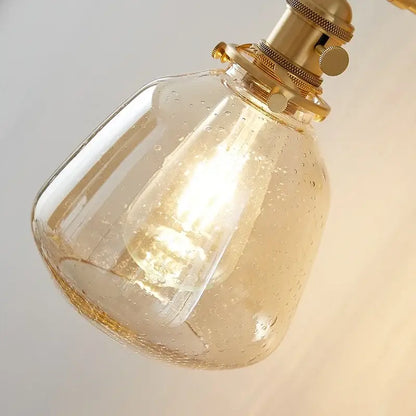 Amber textured clear glass wall sconce with warm-toned amber glass and brass-finished fittings by decorbites clear glass