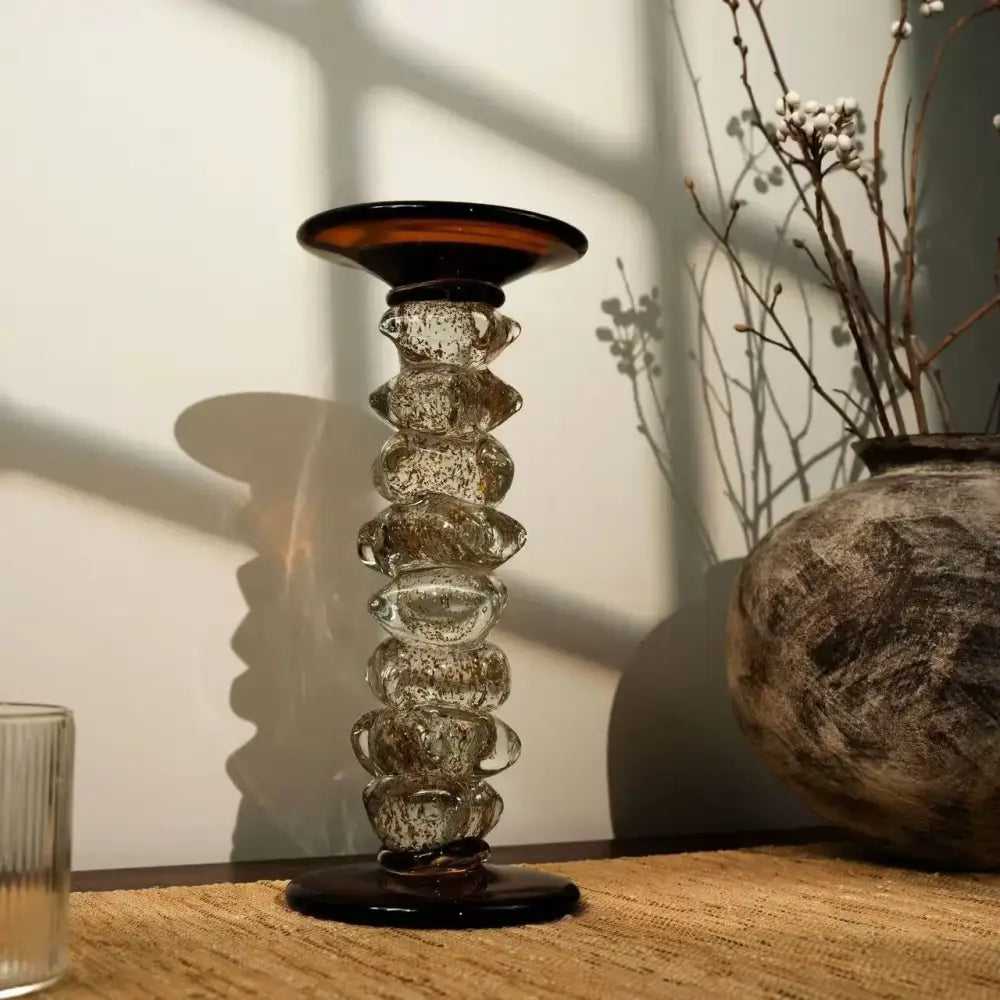 A tall glass splicing candelabrum with dark amber top and base featuring textured bubble-filled translucent segments