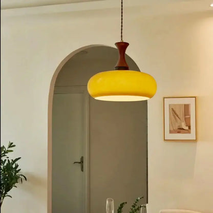 Vibrant yellow amber led pendant light with rounded glass bowl and dark wood metal fixture for kitchen decorbites pendant light