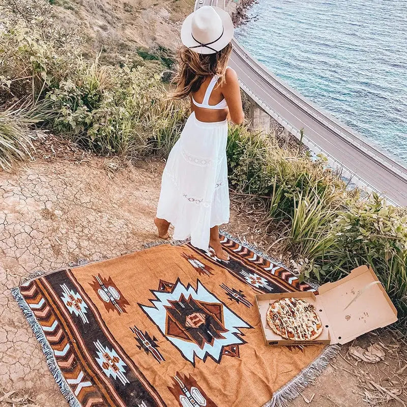 A tan woven american country plaid blanket sofa cover with brown black and light blue geometric pattern for living room