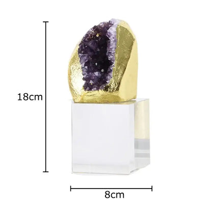 A striking 18cm amethyst crystal base geode with golden foil exterior and purple crystals on an acrylic desk ornament