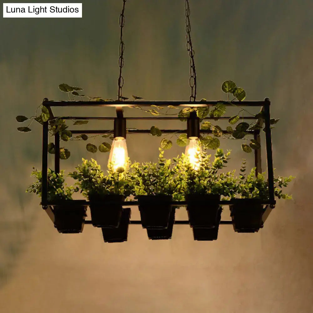 DecorBites™ antique black metal island pendant with two exposed filament bulbs and five small green potted plants