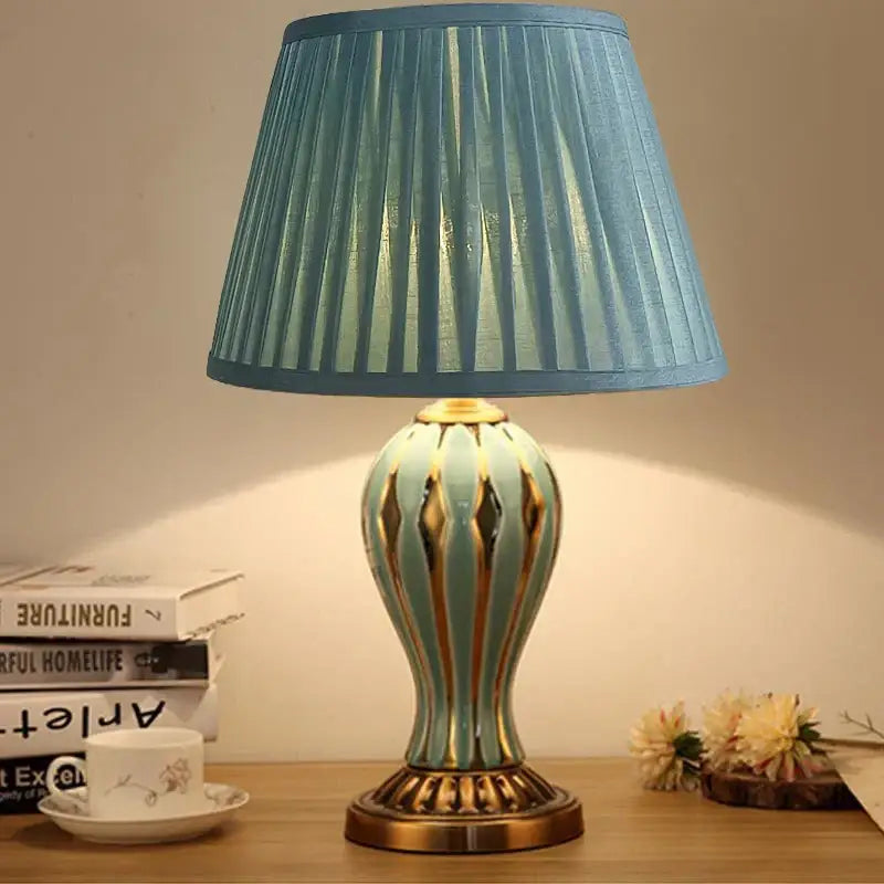 Antique blue ceramic desk lamp with gold vertical stripes and pleated fabric shade for bedroom use