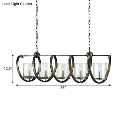 Antique brass dining room chandelier with five clear glass candle holders and lit white taper candles