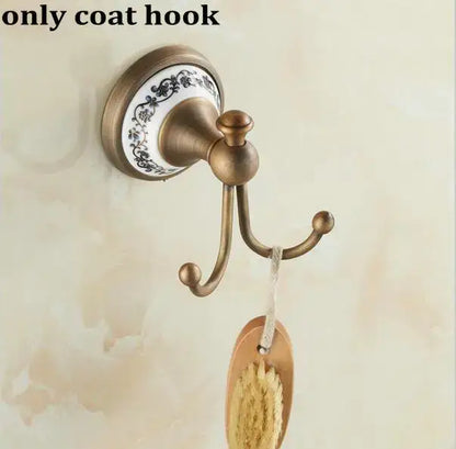 Antique brass coat hook with decorative white ceramic backplate and black floral patterns in decorbites bathroom accessories set