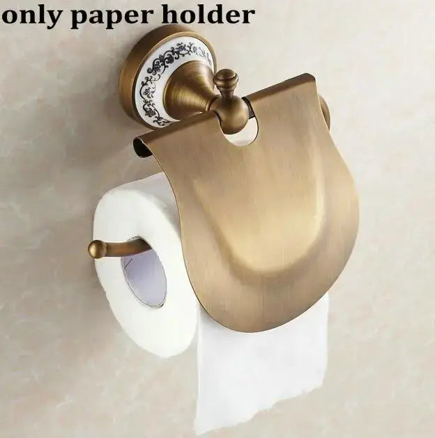 Antique brass toilet paper holder with decorative ceramic base and curved metal cover in decorbites bathroom accessories set
