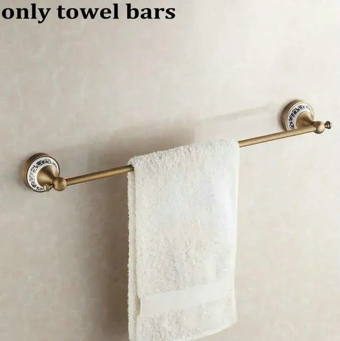 Antique brass towel bar with ornate circular ends and white textured towel in decorbites bathroom accessories set