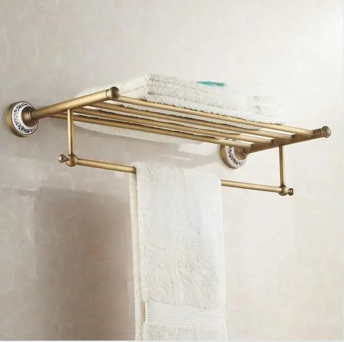 Antique brass and ceramic tiered towel rack with ornate circular mounts holding white towels in decorbites bathroom accessories set