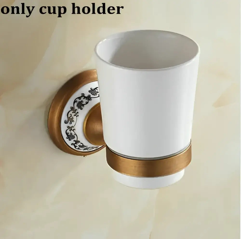 White ceramic cup holder with gold-toned metal and black floral patterns in decorbites bathroom accessories set