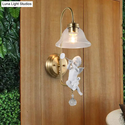 Antique brass angel glass sconce light with white ceramic cherub holding trumpet and clear glass detail