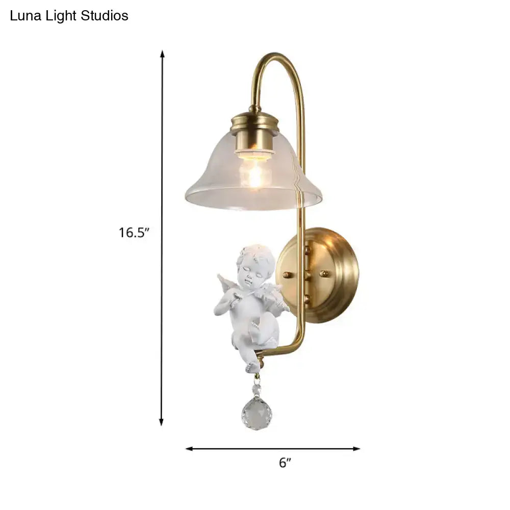 Antique brass glass sconce light featuring a white angel figurine with delicate wings and a clear glass droplet