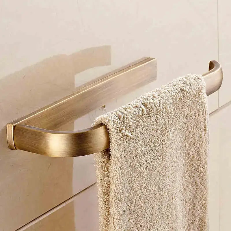 Brass-finished curved towel rack holding a beige textured towel from antique brass bathroom accessories set decorbites bathroom accessories