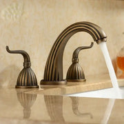 Antique brass bathroom faucet set with three ornate fluted handles and arched spout in brass bathroom faucet design