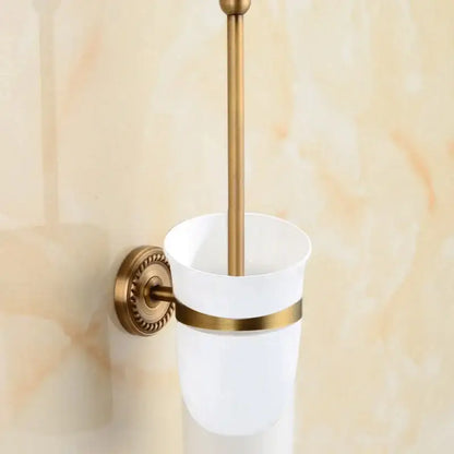 White ceramic toilet brush holder with brass bathroom set featuring decorbites brass ornate mounts and gold-toned handle