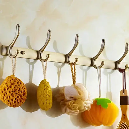 A set of colorful textured bath sponges hanging on a metal rack in an antique brass bathroom set by decorbites brass bathroom