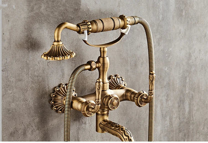 Antique brass bathtub shower set featuring wall-mounted vintage-style faucet with ornate fluted detailing and two hoses