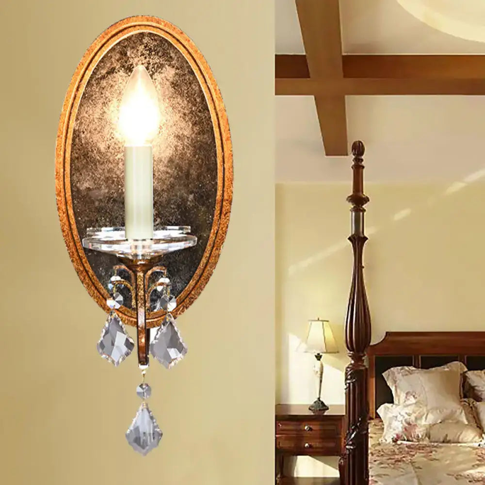 Antique brass oval wall sconce with clear crystal droplets and candle-style bulb for bedroom candle light