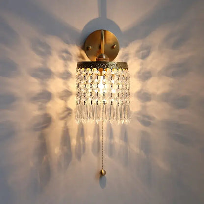 Antique brass crystal led wall sconce with gold-toned finish and cascading clear crystal droplets with pull chain light